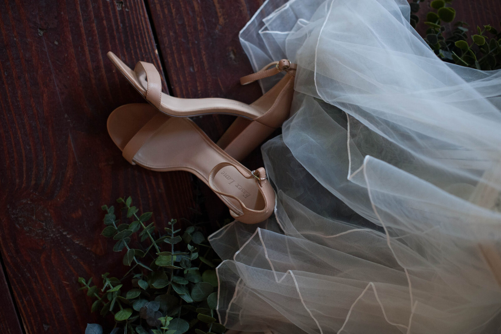 Top down photo of nude strapy sandals with eucalyptus and veil 
