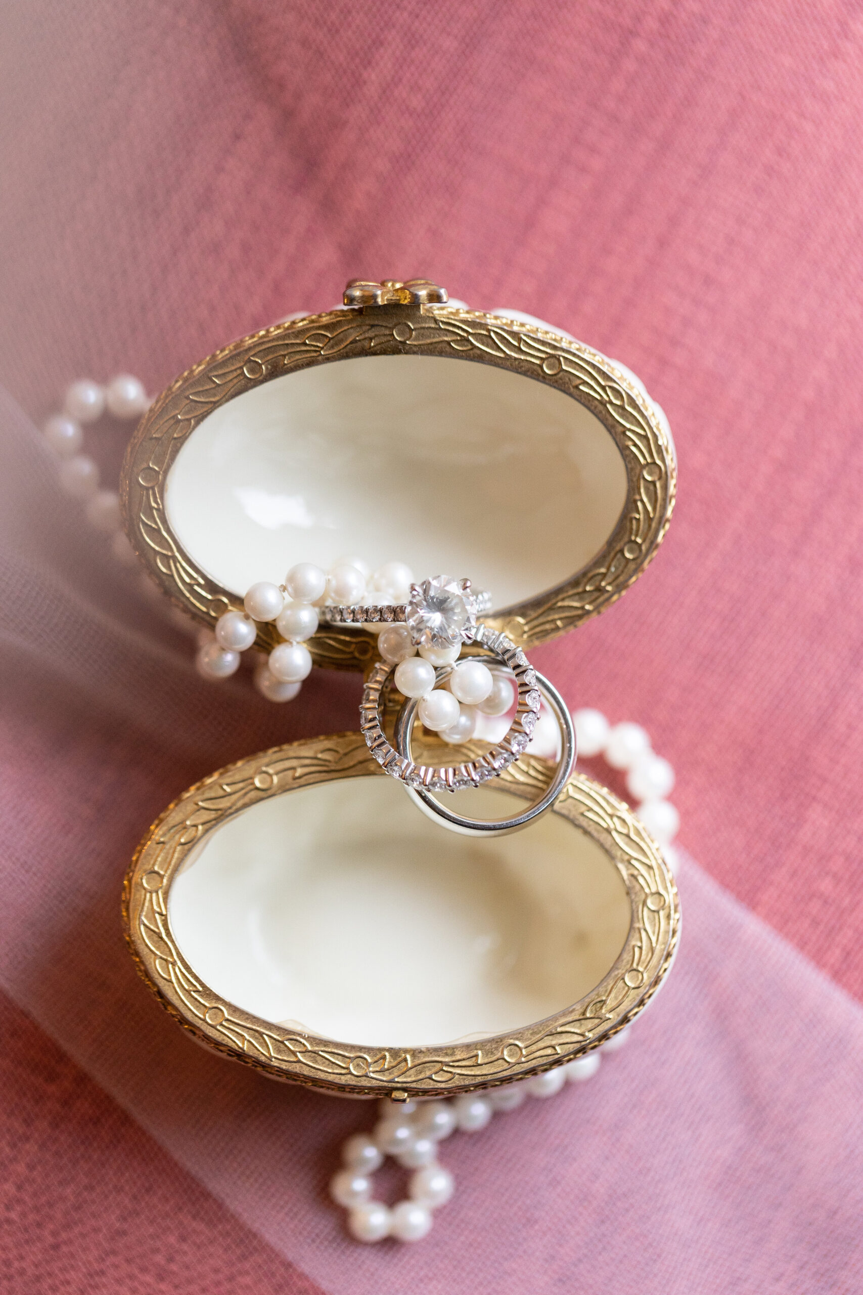 Ring detail shot with draped pearl necklace and clamshell jewelry case at arrowhead bed and breakfast