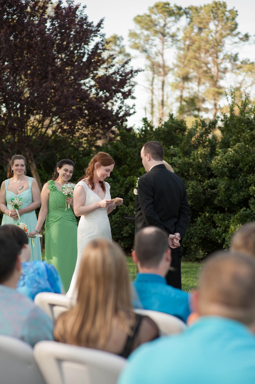 Bride smiles and laughs at her groom during their outdoor wedding ceremony